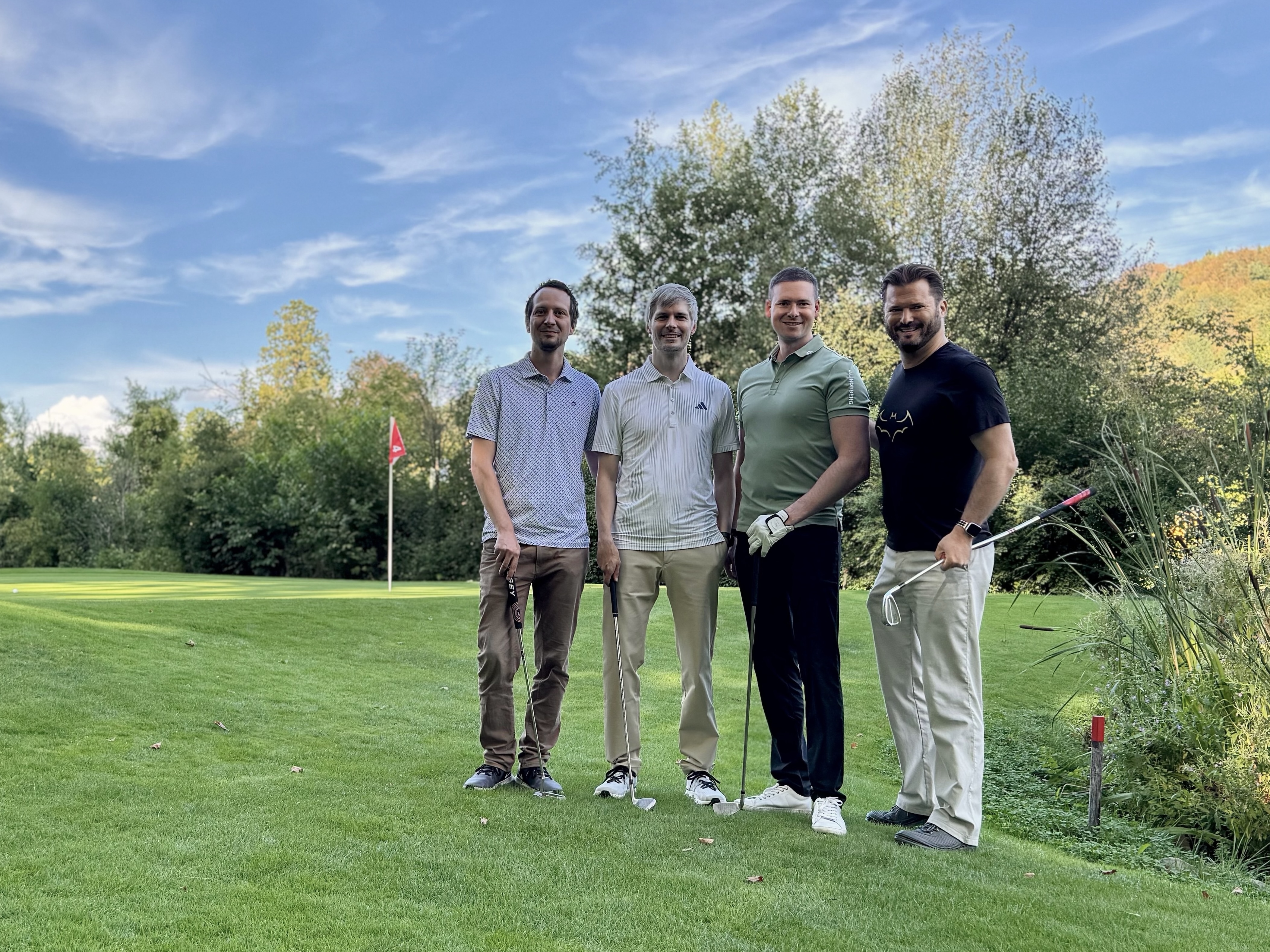 Vier Mitglieder der EMBA 65 Golfgruppe gemeinsam auf dem Golfplatz.