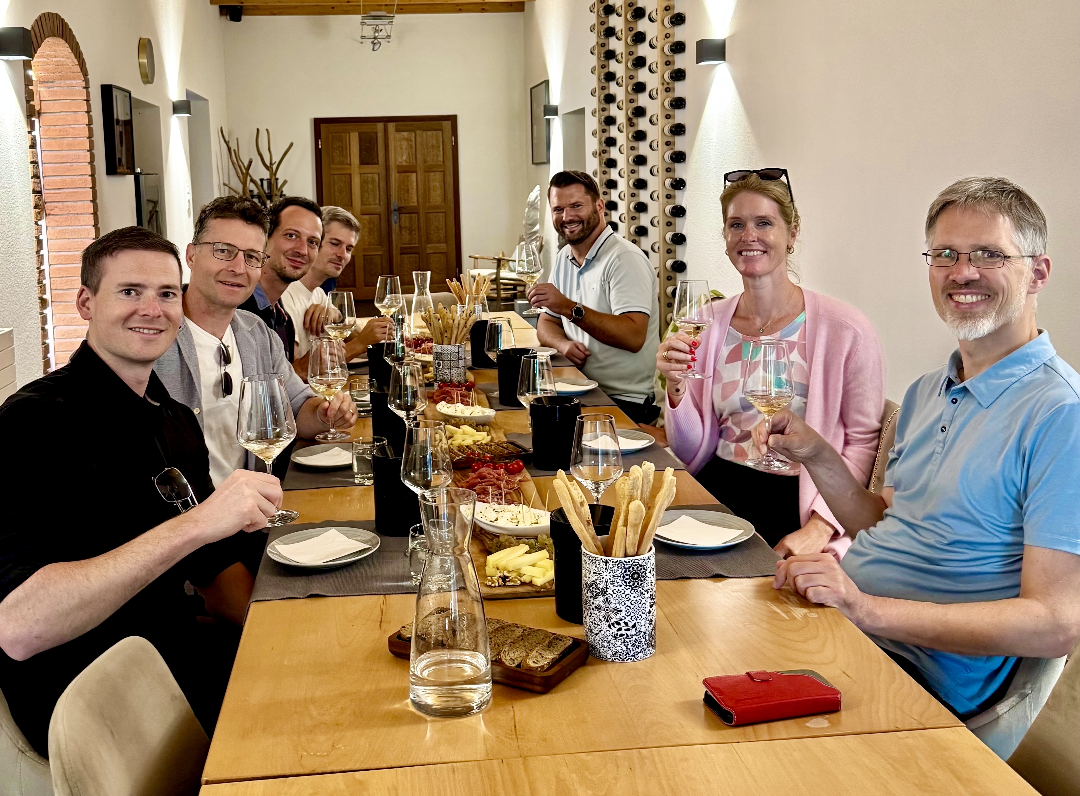 Gemeinsame Weindegustation an einem gedeckten Tisch mit Weingläsern und Apéro.